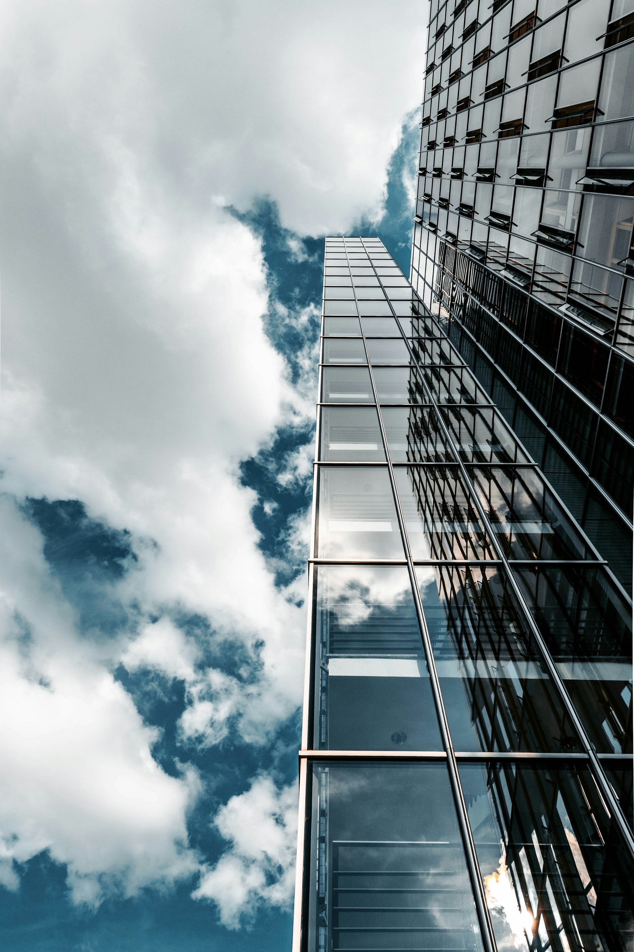 Reflective glass office architecture photographed against a cloudy sky
